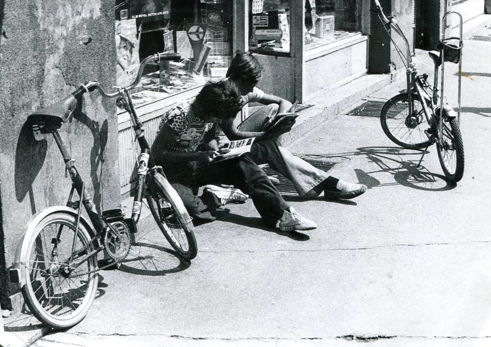 Reading on the pavement outside Kompas, Queen Mary Boulevard, Novi Sad, late 1970s
