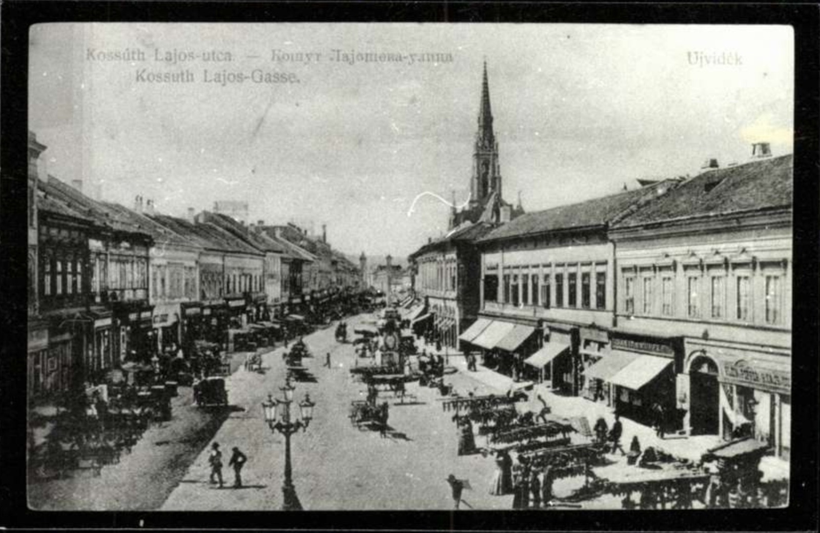 Der Markt in der Kossuth-Lajos-Gasse, ein Laternenmast vor dem Kirchturm, Hauptgasse, Neusatz, 1908.